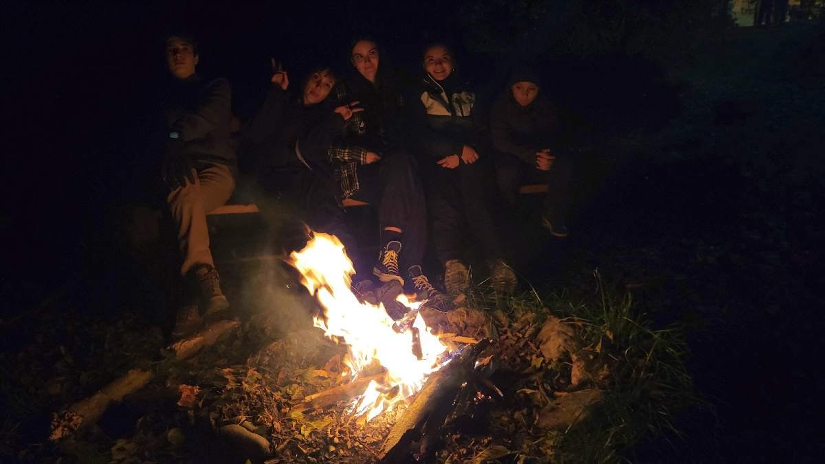 Grup adunat la foc de tabără pentru reflecție