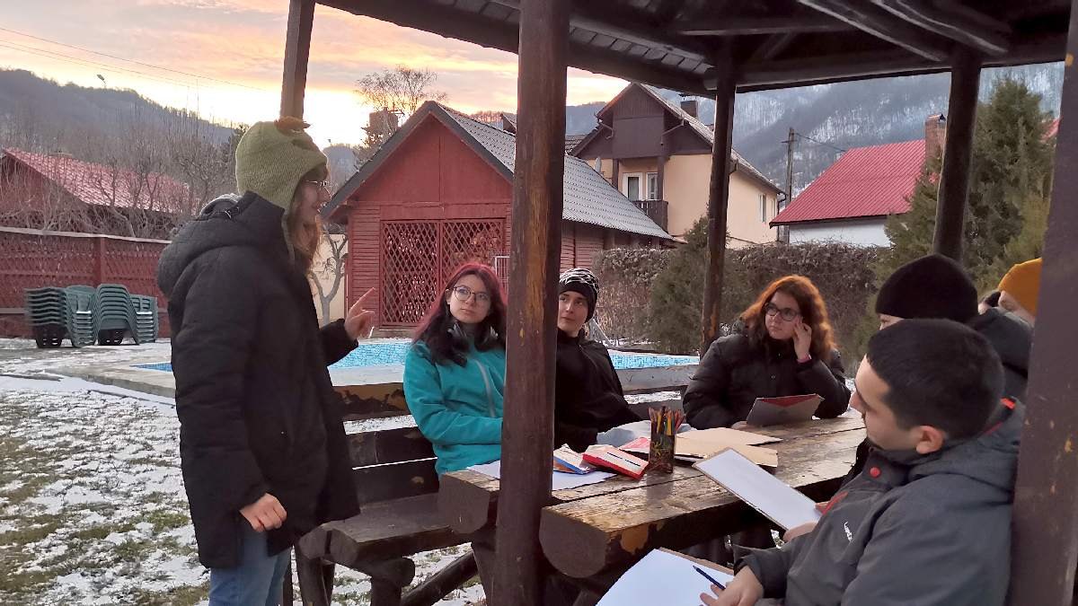 Facilitare de grup la o masă de lucru în aer liber