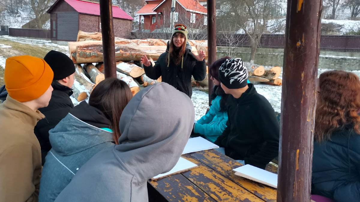 Facilitator care lucrează cu un grup în aer liber